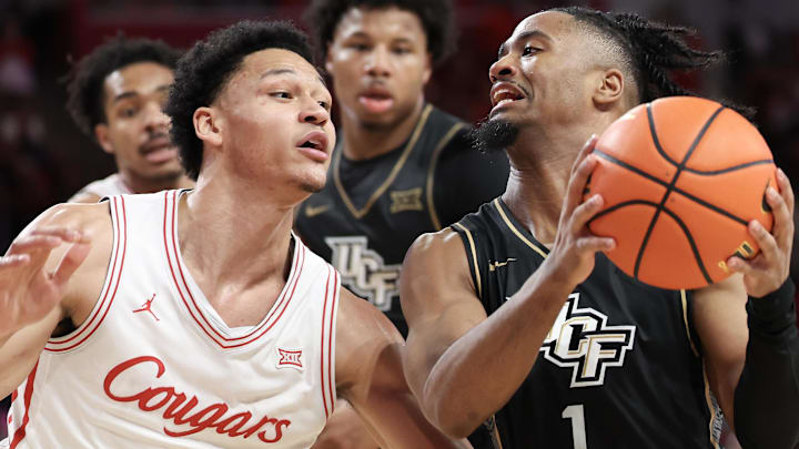Feb 4, 2026; Houston, Texas, USA; UCF Knights guard Themus Fulks (1) drives against Houston Cougars guard Isiah Harwell (1) in the second half at Fertitta Center.
