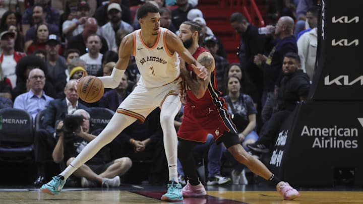 Feb 7, 2024; Miami, Florida, USA; San Antonio Spurs center Victor Wembanyama (1) dribbles the basketball against Miami Heat forward Caleb Martin (16) during the first quarter at Kaseya Center.