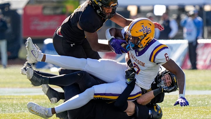 Dec 6, 2024; Birmingham, AL, USA; A trio of Cherokee County defenders bring down Jackson's Keeyun Chapman (6) at Protective Stadium in the AHSAA 4A State Championship game.