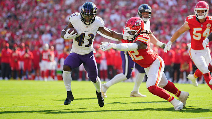 Sep 28, 2025; Kansas City, Missouri, USA; Baltimore Ravens running back Justice Hill (43) breaks a tackle from Kansas City Chiefs linebacker Nick Bolton (32) to score a touchdown during the first quarter at GEHA Field at Arrowhead Stadium. Mandatory Credit: Jay Biggerstaff-Imagn Images