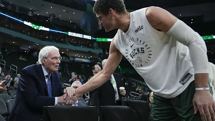 Feb 9, 2025; Milwaukee, Wisconsin, USA;  ESPN broadcaster Hubie Brown talks with Milwaukee Bucks center Brook Lopez (11) prior to the game against the Philadelphia 76ers at Fiserv Forum. Mandatory Credit: Jeff Hanisch-Imagn Images