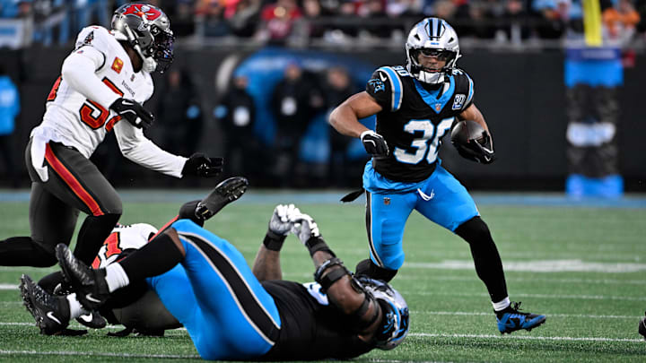 Dec 1, 2024; Charlotte, North Carolina, USA;  Carolina Panthers running back Chuba Hubbard (30) runs as Tampa Bay Buccaneers linebacker Lavonte David (54) defends in the second quarter at Bank of America Stadium. Mandatory Credit: Bob Donnan-Imagn Images