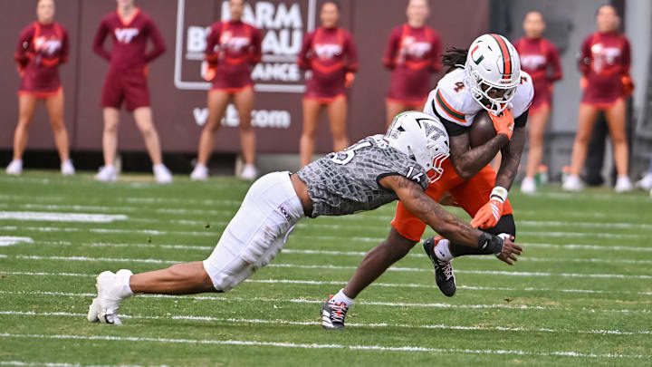 Nov 22, 2025; Blacksburg, Virginia, USA; Virginia Tech Hokies linebacker Noah Chambers (16) tackles Miami (FL) Hurricanes running back Mark Fletcher Jr. (4) during the third quarter at Lane Stadium. Mandatory Credit: Brian Bishop-Imagn Images Nov 22, 2025; Blacksburg, Virginia, USA; Virginia Tech Hokies linebacker Noah Chambers (16) tackles Miami (FL) Hurricanes running back Mark Fletcher Jr. (4) during the third quarter at Lane Stadium. Mandatory Credit: Brian Bishop-Imagn Images