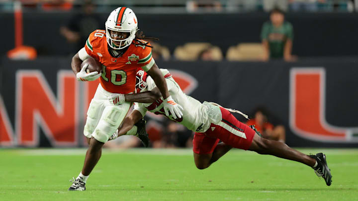 Oct 17, 2025; Miami Gardens, Florida, USA; Miami Hurricanes wide receiver Malachi Toney (10) carries the football against Louisville Cardinals defensive back Tayon Holloway (25) during the fourth quarter at Hard Rock Stadium. Mandatory Credit: Sam Navarro-Imagn Images