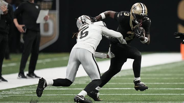 Sep 27, 2026; New Orleans, Louisiana, USA;  New Orleans Saints running back Travis Etienne Jr. (3) runs with the ball while defended by Las Vegas Raiders cornerback Eric Stokes (5) in the second half at Caesars Superdome.  Mandatory Credit: Matthew Hinton-Imagn Images