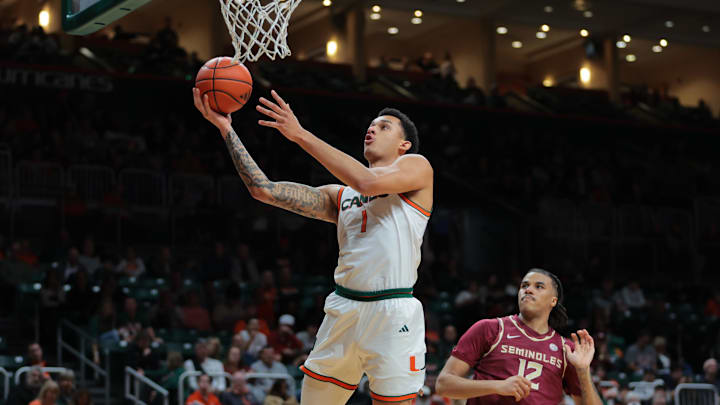 Jan 8, 2025; Coral Gables, Florida, USA; Miami Hurricanes center Lynn Kidd (1) drives to the basket past Florida State Seminoles forward Malique Ewin (12) during the second half at Watsco Center. Mandatory Credit: Sam Navarro-Imagn Images