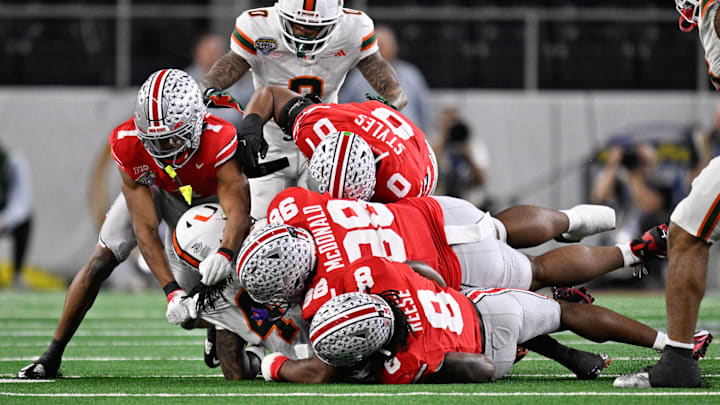 Dec 31, 2025; Arlington, TX, USA; Miami Hurricanes defensive lineman Rueben Bain Jr. (4) is tackled by Ohio State Buckeyes wide receiver Brandon Inniss (1),  linebacker Sonny Styles (0), defensive lineman Kayden McDonald (98) and Ohio linebacker Arvell Reese (8) during the first quarter of the 2025 Cotton Bowl and quarterfinal game of the College Football Playoff at AT&T Stadium. Mandatory Credit: Jerome Miron-Imagn Images