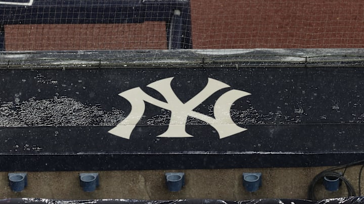 Aug 17, 2020; Bronx, New York, USA; A general view of rain falling on the  New York Yankees logo on the first base dugout roof during a rain delay in the game between the New York Yankees and the Boston Red Sox. Mandatory Credit: Vincent Carchietta-Imagn Images