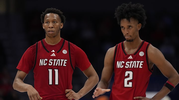 Mar 12, 2026; Charlotte, NC, USA; NC State Wolfpack guard Quadir Copeland (11) and guard Jr. Paul McNeil (2) in the final seconds during the second half against the Virginia Cavaliers at Spectrum Center. Mandatory Credit: Jim Dedmon-Imagn Images