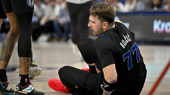 Feb 3, 2024; Dallas, Texas, USA; Dallas Mavericks guard Luka Doncic (77) appears to suffer a leg injury as he battles for the loose ball with Milwaukee Bucks forward Giannis Antetokounmpo (34) during the first quarter at the American Airlines Center. Mandatory Credit: Jerome Miron-Imagn Images