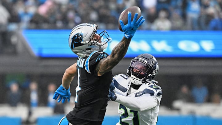 Dec 28, 2025; Charlotte, North Carolina, USA; Carolina Panthers wide receiver Tetairoa McMillan (4) extends but cannot catch a pass against Seattle Seahawks cornerback Devon Witherspoon (21) during the second quarter at Bank of America Stadium.