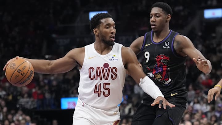Feb 12, 2025; Toronto, Ontario, CAN; Cleveland Cavaliers guard Donovan Mitchell (45) drives to the net against Toronto Raptors guard RJ Barrett (9) during the second half at Scotiabank Arena. Mandatory Credit: John E. Sokolowski-Imagn Images