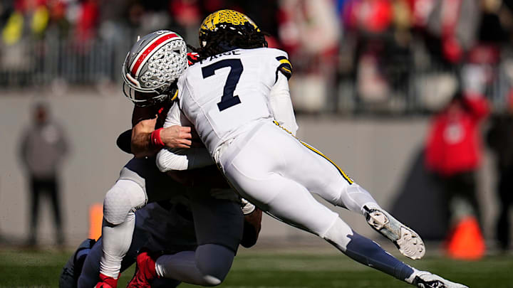 Ohio State Buckeyes quarterback Will Howard (18) is hit by Michigan Wolverines defensive back Makari Paige (7) during the first half of the NCAA football game at Ohio Stadium in Columbus on Saturday, Nov. 30, 2024. Howard left the game briefly after the play.