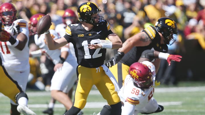 Iowa Hawkeyes's quarter Cade McNamara (12) passes the ball around Iowa State Cyclones defensive line J.R. Singleton (58) during the first quarter in the Cy-Hawk series at Kinnick Stadium on Saturday, Sept. 7, 2024, in Iowa City, Iowa.