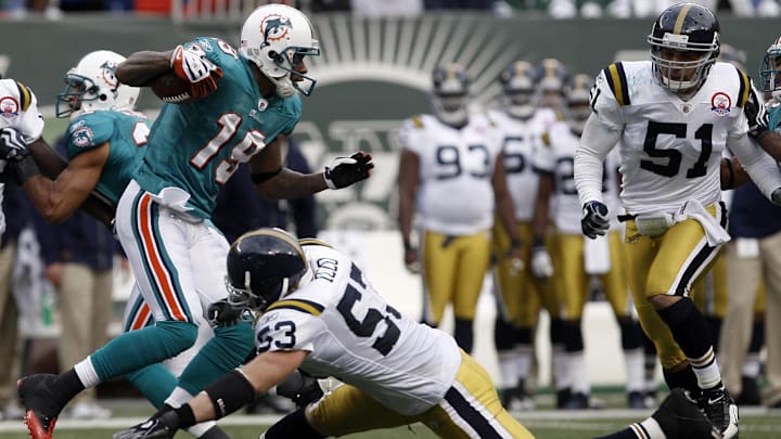 Miami Dolphins wide receiver Ted Ginn Jr. (19) avoids a tackle by New York Jets linebacker Larry Izzo (53) while running back his second kickoff for a touchdown during the second half at Giants Stadium in 2009. Miami Dolphins wide receiver Ted Ginn Jr. (19) avoids a tackle by New York Jets linebacker Larry Izzo (53) while running back his second kickoff for a touchdown during the second half at Giants Stadium in 2009.