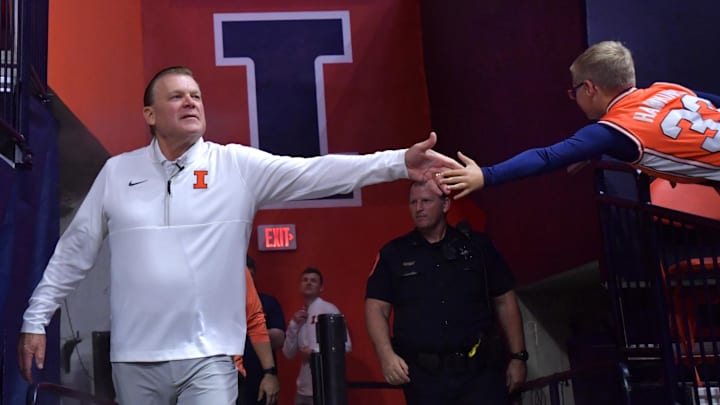 Nov 4, 2024; Champaign, Illinois, USA;  Illinois Fighting Illini head coach Brad Underwood gets a hand from a young fan before a game against the Eastern Illinois Panthers at State Farm Center. Mandatory Credit: Ron Johnson-Imagn Images