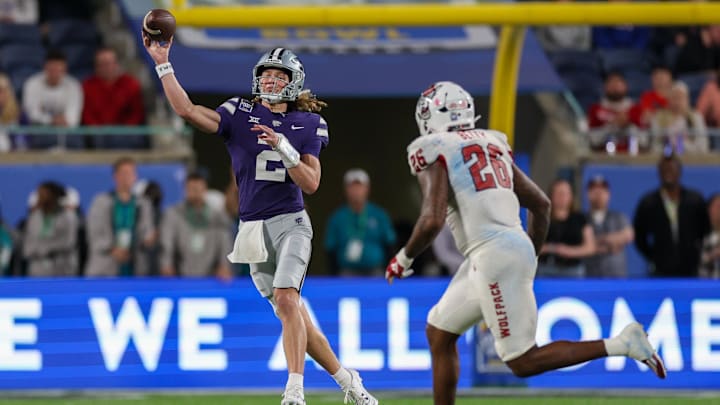 Dec 28, 2023; Orlando, FL, USA;  Kansas State Wildcats quarterback Avery Johnson (2) throws a pass guarded by North Carolina State Wolfpack linebacker Devon Betty (26) in the fourth quarter during the Pop-Tarts Bowl at Camping World Stadium. Mandatory Credit: Nathan Ray Seebeck-USA TODAY Sports