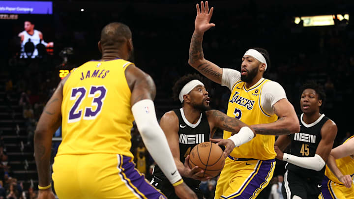 Memphis Grizzlies guard Jordan Goodwin (4) drives to the basket between Los Angeles Lakers forward LeBron James (23) and forward Anthony Davis (3) during the second half at FedExForum. Mandatory Credit: Petre Thomas-Imagn Images