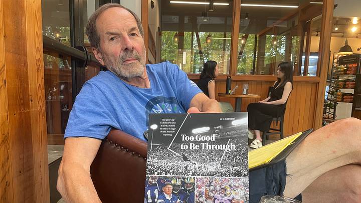 Bud Withers shows off his Apple Cup book, Too Good to be Through. Bud Withers shows off his Apple Cup book, Too Good to be Through.