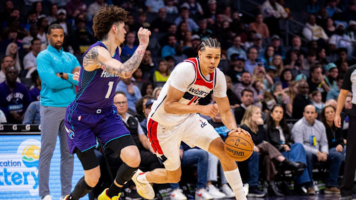 Mar 1, 2025; Charlotte, North Carolina, USA; Washington Wizards forward Kyshawn George (18) drives on Charlotte Hornets guard LaMelo Ball (1) during the fourth quarter at Spectrum Center. Mandatory Credit: Scott Kinser-Imagn Images
