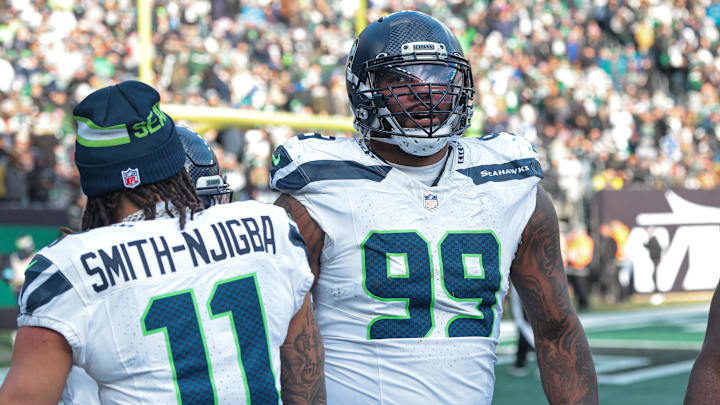 Dec 1, 2024; East Rutherford, New Jersey, USA; Seattle Seahawks defensive end Leonard Williams (99) celebrates his interception return for a touchdown during the first half against the New York Jets at MetLife Stadium. Mandatory Credit: Vincent Carchietta-Imagn Images