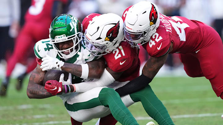 Nov 10, 2024; Glendale, Arizona, USA; Arizona Cardinals safety Dadrion Taylor-Demerson (42) and Arizona Cardinals cornerback Garrett Williams (21) tackle New York Jets wide receiver Malachi Corley (14) during the first half at State Farm Stadium. 