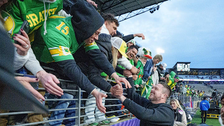 Oregon head coach Dan Lanning celebrates with fans after the Ducks dumped the Dawgs in Seattle.