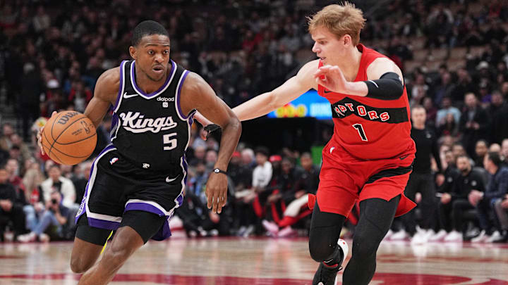 Mar 20, 2024; Toronto, Ontario, CAN; Sacramento Kings guard De'Aaron Fox (5) controls the ball as Toronto Raptors guard Gradey Dick (1) tries to defend during the first quarter at Scotiabank Arena. Mandatory Credit: Nick Turchiaro-Imagn Images