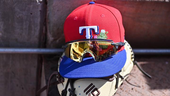 General view of a Texas Rangers hat sitting on top of a baseball glove. General view of a Texas Rangers hat sitting on top of a baseball glove.