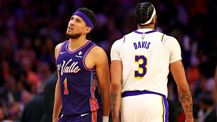 Feb 25, 2024; Phoenix, Arizona, USA; Phoenix Suns guard Devin Booker (1) walks past Los Angeles Lakers forward Anthony Davis (3) during the second quarter at Footprint Center. Mandatory Credit: Mark J. Rebilas-Imagn Images