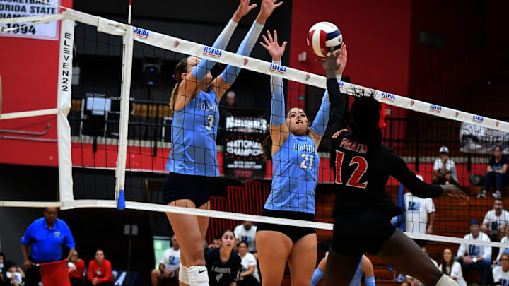 Miami Lourdes Academy seniors Olivia Guzman (3) and Gianna Diaz (21) go up to block a shot from Port Charlotte senior Nygeria Hart during a Class 5A semifinal matchup at the FHSAA state tournament on Thursday at Polk State College.