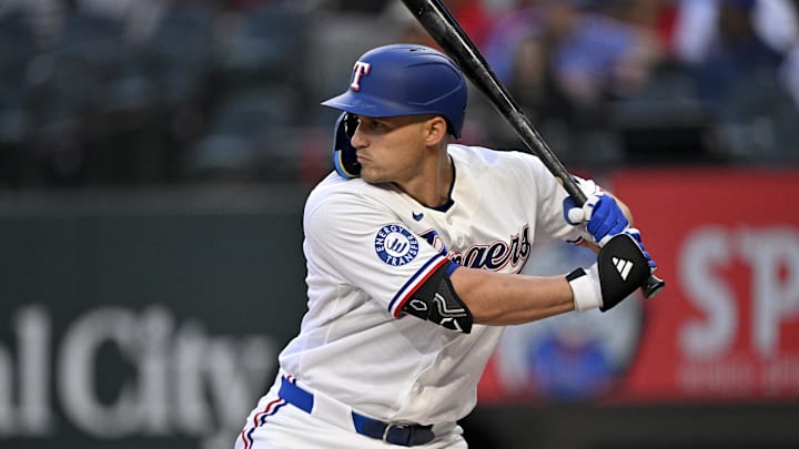 Texas Rangers shortstop Corey Seager prepares to swing his bat at a baseball. 