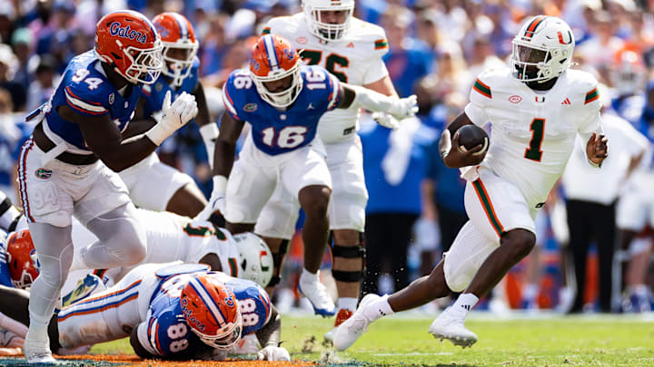Aug 31, 2024; Gainesville, Florida, USA; Miami Hurricanes quarterback Cam Ward (1) breaks a tackle against Florida Gators defensive lineman Caleb Banks (88) and defensive end Tyreak Sapp (94) during the first half at Ben Hill Griffin Stadium. Mandatory Credit: Matt Pendleton-USA TODAY Sports