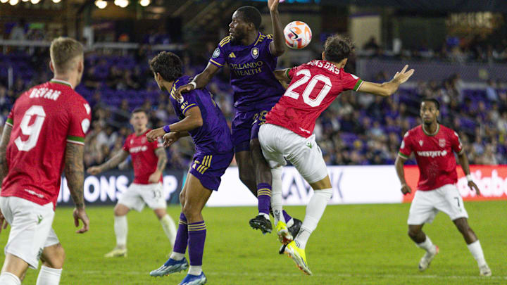 Feb 27, 2024; Orlando, FL, USA; Orlando City defender Abdi Salim (28), forward Ramiro Enrique (7), and Calvary FC midfielder Lucas Dias (20) go up for a header in the second half at Interz7Co Stadium. Mandatory Credit: Morgan Tencza-USA TODAY Sports