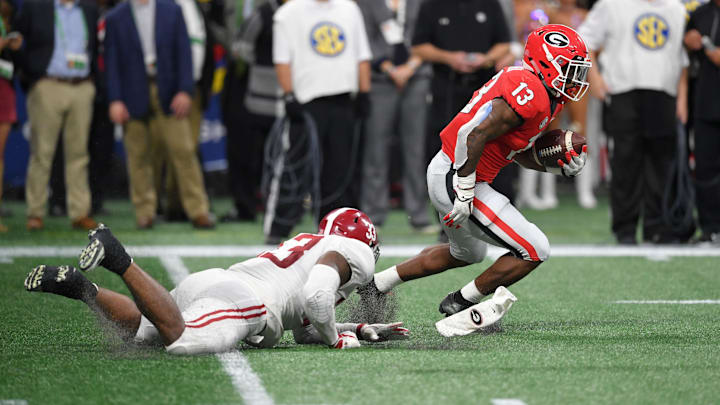 Dec 1, 2018; Atlanta, GA, USA; Georgia Bulldogs running back Elijah Holyfield (13) carries the ball Alabama Crimson Tide linebacker Anfernee Jennings (33) during the second quarter in the SEC championship game at Mercedes-Benz Stadium. Mandatory Credit: Dale Zanine-Imagn Images Dec 1, 2018; Atlanta, GA, USA; Georgia Bulldogs running back Elijah Holyfield (13) carries the ball Alabama Crimson Tide linebacker Anfernee Jennings (33) during the second quarter in the SEC championship game at Mercedes-Benz Stadium. Mandatory Credit: Dale Zanine-Imagn Images