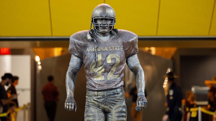 Arizona State's football players walk past Pat Tillman's statue as they enter Mountain America Stadium in Tempe, Arizona.