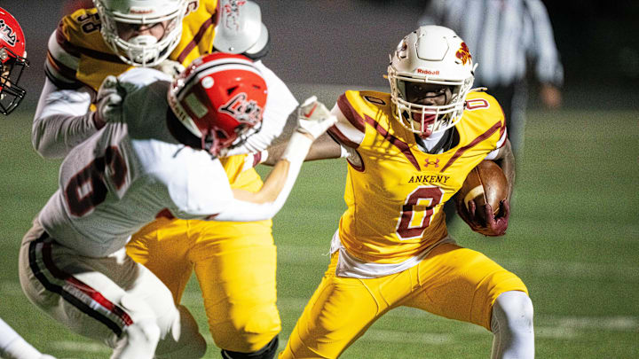 Ankeny's Daniel Larmie (0) stiff arms a defender as he fights for yards on Friday, Nov. 1, 2024, at Ankeny Stadium.