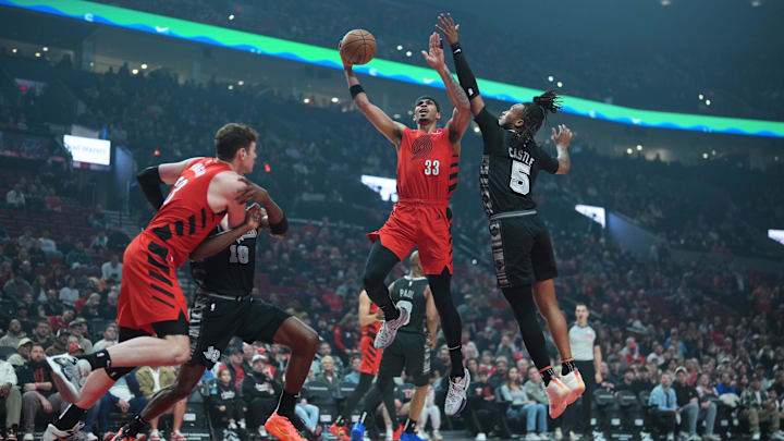 Apr 6, 2025; Portland, Oregon, USA: Portland Trail Blazers forward Toumani Camara (33) lays up a shot against San Antonio Spurs guard Stephon Castle (5) during the first half at Moda Center. Mandatory Credit: Soobum Im-Imagn Images