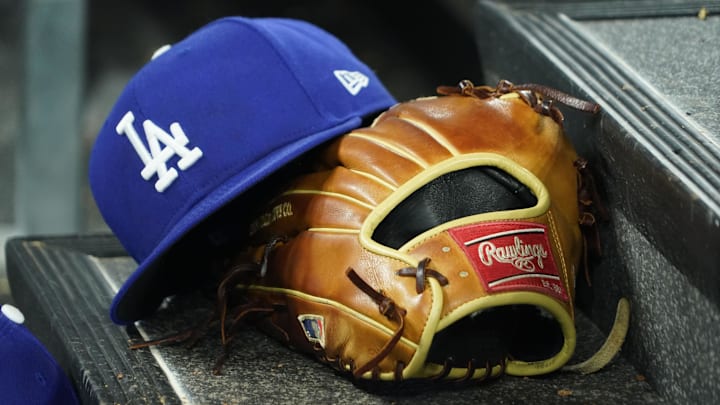 Apr 28, 2024; Toronto, Ontario, CAN; A hat and glove of an Los Angeles Dodgers player durng a game against the Toronto Blue Jays at Rogers Centre. Mandatory Credit: John E. Sokolowski-Imagn Images