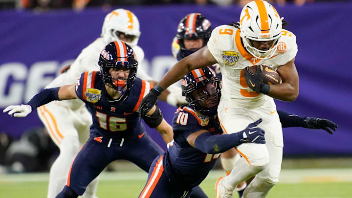 Tennessee running back Star Thomas (9) is stopped by Illinois defensive back Miles Scott (10) in the third quarter of the Music City Bowl NCAA college football game on Dec. 30, 2025, in Nashville, Tennessee.