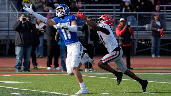 Novi Detroit Catholic Central (11) Gideon Gash stretches out on a ball thrown too high for him as East Kentwood (11) Stephan Jones defends during the first half of the MHSAA Division 1 football semifinals between Novi Detroit Catholic Central and East Kentwood at Jackson High School in Jackson on Saturday, Nov. 22, 2025.