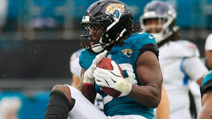 Jacksonville Jaguars linebacker Devin Lloyd (33) picks up an interception on a pass intended for and tipped by Tennessee Titans running back Julius Chestnut (36) during the second quarter of an NFL football matchup Sunday, Dec. 29, 2024 at EverBank Stadium in Jacksonville, Fla. [Corey Perrine/Florida Times-Union]