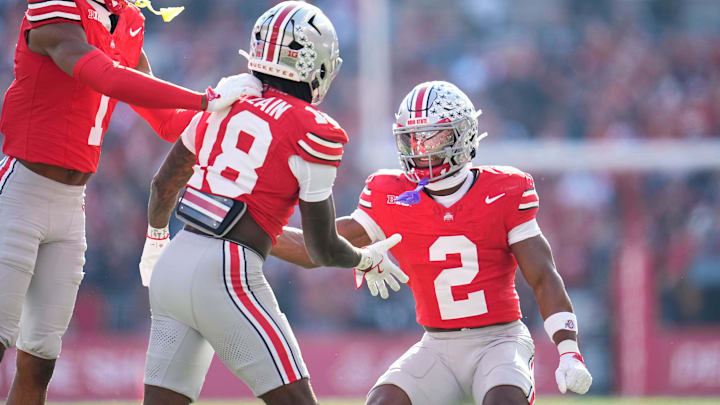 Ohio State Buckeyes cornerback Davison Igbinosun (1) and defensive back Caleb Downs (2) celebrate with safety Jaylen McClain (18) during the first half of the NCAA football game against the Rutgers Scarlet Knights at Ohio Stadium in Columbus on Nov. 22, 2025.