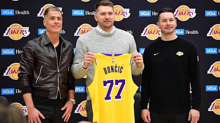 Los Angeles Lakers guard Luka Doncic poses for photos with general manager Rob Pelinka and head coach JJ Redick.