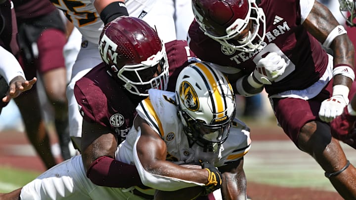 Oct 5, 2024; College Station, Texas, USA; Texas A&M Aggies defensive lineman Albert Regis (17) and linebacker Scooby Williams (0) stop Missouri Tigers running back Marcus Carroll (9) in the fourth quarter at Kyle Field. Mandatory Credit: Maria Lysaker-Imagn Images. 