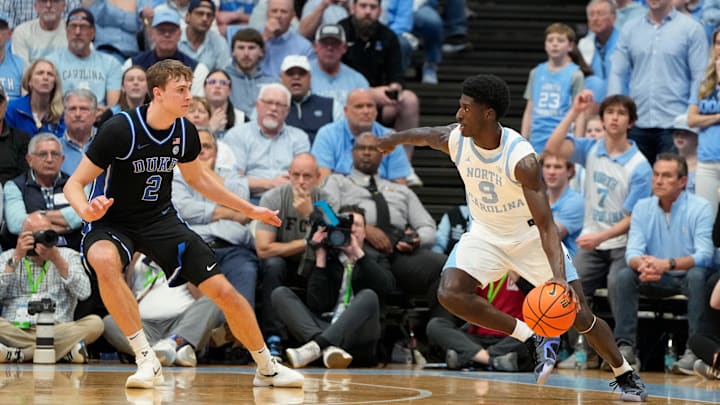 Mar 8, 2025; Chapel Hill, North Carolina, USA; North Carolina Tar Heels guard Drake Powell (9) dribbles as Duke Blue Devils forward Cooper Flagg (2) defends in the first half at Dean E. Smith Center. Mandatory Credit: Bob Donnan-Imagn Images