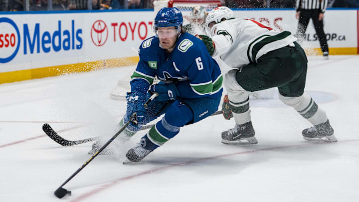 Apr 12, 2025; Vancouver, British Columbia, CAN; Minnesota Wild forward Matt Boldy (12) checks Vancouver Canucks forward Brock Boeser (6) in overtime at Rogers Arena. Mandatory Credit: Bob Frid-Imagn Images