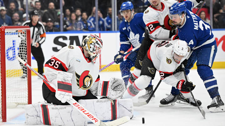 Mar 15, 2025; Toronto, Ontario, CAN;  Ottawa Senators goalie Linus Ullmark (35) makes a save as defensemen Artem Zub (2) and Thomas Chabot (72) hold back Toronto Maple Leafs forward Auston Matthews (34) in the third period at Scotiabank Arena. Mandatory Credit: Dan Hamilton-Imagn Images