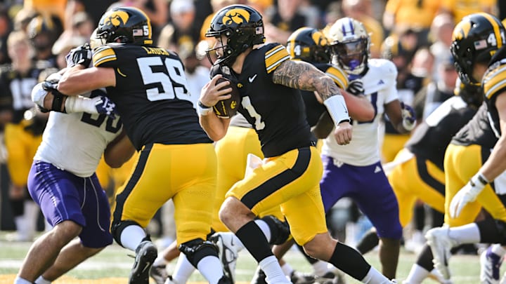 Oct 12, 2024; Iowa City, Iowa, USA; Iowa Hawkeyes quarterback Brendan Sullivan (1) runs the ball for a short gain during the fourth quarter against the Washington Huskies at Kinnick Stadium. Mandatory Credit: Jeffrey Becker-Imagn Images