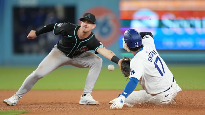 May 21, 2024; Los Angeles, California, USA; Los Angeles Dodgers designated hitter Shohei Ohtani (17) slides into second base for a stolen base against Arizona Diamondbacks shortstop Kevin Newman (18) at Dodger Stadium. Mandatory Credit: Kirby Lee-USA TODAY Sports